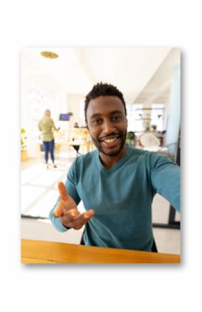 Portrait of happy casual african american businessman looking at camera in modern office