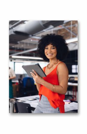 Portrait of happy african american businesswoman using tablet and smiling at office, unaltered