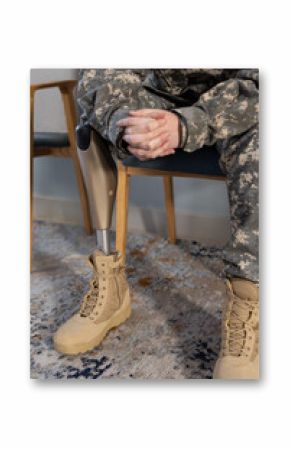 Sitting in uniform, soldier with prosthetic leg resting hands on lap