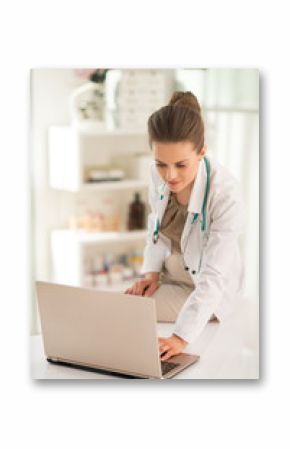 Medical doctor woman working on laptop in office