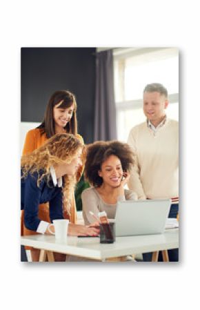 Young people working in modern office, discussing in front of laptop