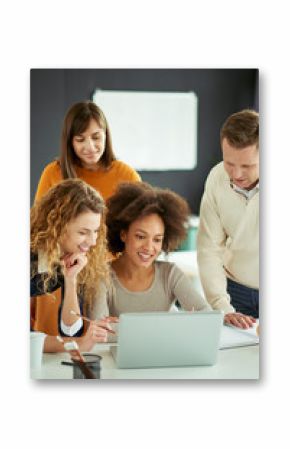 Young people working in modern office, discussing in front of laptop