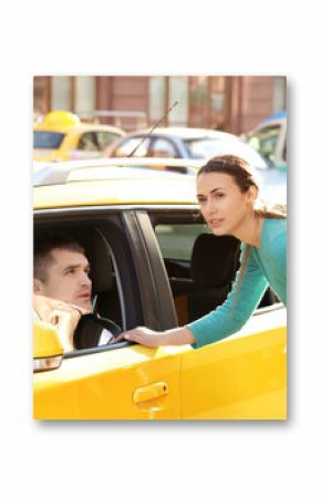 Young woman talking to male taxi driver while standing near car