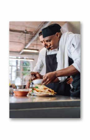 Chefs preparing food together in restaurant kitchen