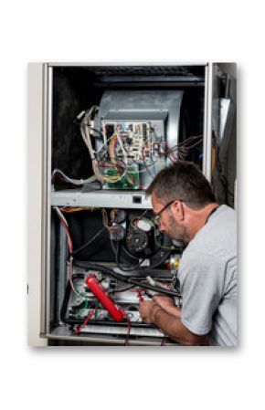 Master technician works on a home furnace with volt meter