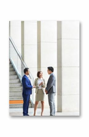 Multiethnic group of business people standing and talking to each other before meeting at office corridor