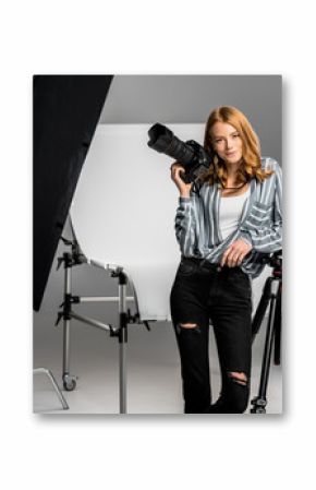 attractive young female photographer working in professional photo studio