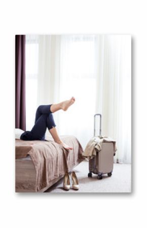 Hotel room. Shoes of a nice relaxed young woman standing near her bed in the hotel room