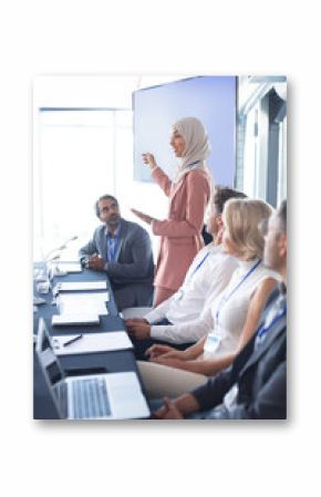 Businesswoman giving presentation at table in business seminar