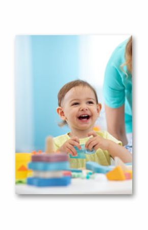 Babies play with teacher in nursery or creche