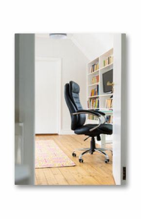 Cozy home office with black chair and bookshelf, ready for work