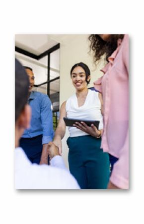 Shaking hands during office meeting, businesswoman smiling and using tablet