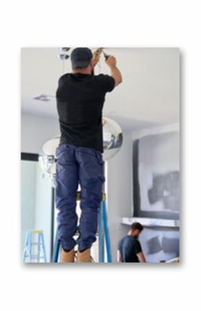 Electrician hanging globe lights and electrician working in distance