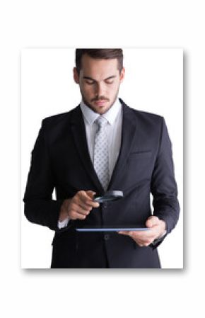 Concentrated businessman using magnifying glass