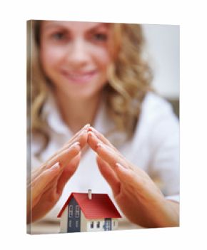 Frau hält Hände über Haus