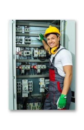 Cheerful electrician in a safety hat on a factory