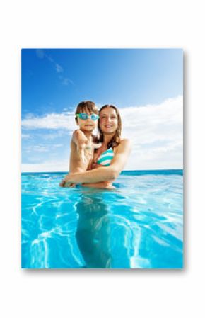 Mother holds son with goggles and smiles in pool