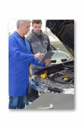 student mechanic learning from teacher in automotive vocational school