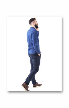 Rear side view of young elegant smart casual business man talking on the phone walking and looking up. Full body isolated on white background. 
