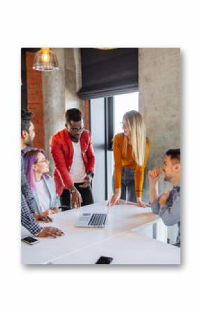 Diverse multiethnic group of young businesspeople in office boardroom gathering together around white table, discussing their business strategy and sharing information