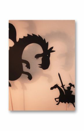 Shadow Puppets of Dragon, Princess and Knight with bright glowing screen of shadow theatre in the background. 