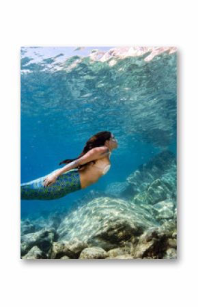 Mermaid swimming underwater in the deep blue sea