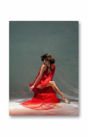 Graceful lady in scarlet dress posing underwater