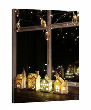 Gold lights hanging with little white houses in window