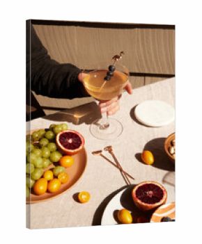 Person holding a cocktail glass among different foods