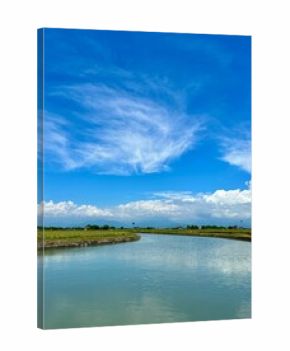 Scenic view of an artificial lake under a bright cloudy sky