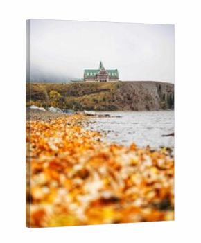 Waterton lakes national park lakeshore in autumn foliage season under cloudy sky, landmarks, Canada