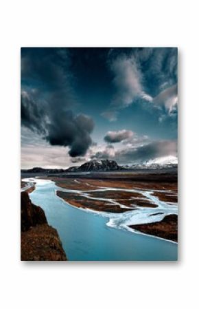 Vertical shot of river flowing on the frozen ground of an island in winter