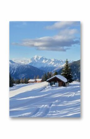 Vertical shot of the small huts nestled between the snowy mountains