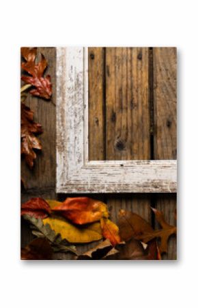 Overhead view of autumn leaves and empty old picture frame over wooden table