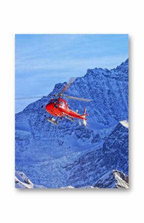 Red helicopter in swiss alps in winter sunshine