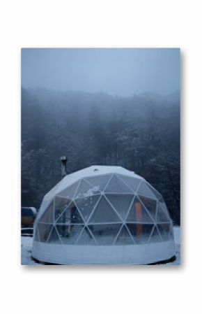 Exterior of spherical glamping cupola in winter snowy forest