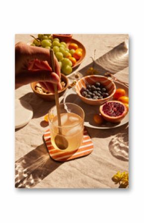 Hand holding a cocktail glass among different foods