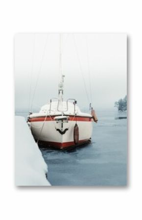 Vertical shot of a boat covered in snow under a cloudy sky during winter
