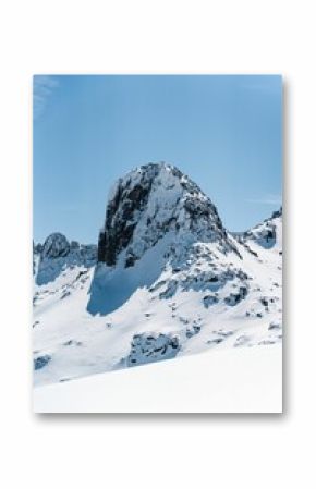 Vertical shot of  snowy peaks of cliffs on a sunny day