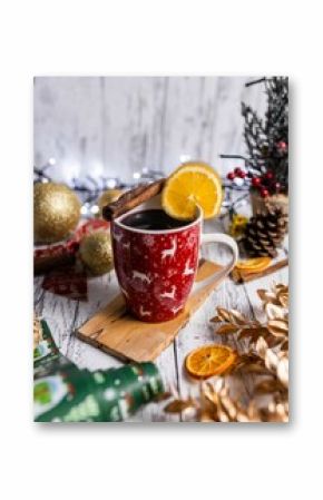 Vertical shot of the Christmas mulled wine in a festive cup with cinnamon sticks and slice of lemon