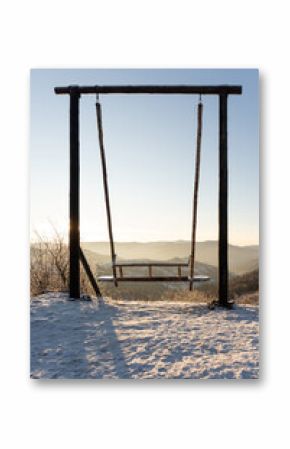 View of wooden swing at the hill in a snowy winter
