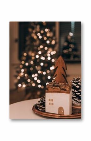 Vertical shot of a wooden decoration on the blurred bokeh background of a Christmas tree