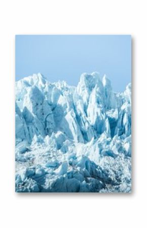 Vertical shot of icy glaciers and wild nature in Alaska in blue sky background