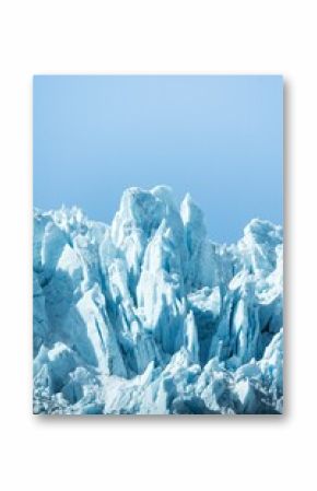 Vertical shot of icy glaciers and wild nature in Alaska in blue sky background