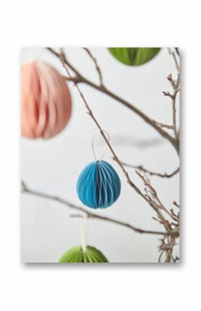 Colorful papercraft ornaments hung on branches.