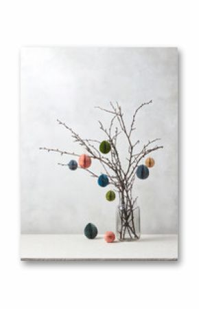 Colorful paper Easter eggs hung on tree branches.