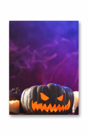 Vertical image of pumpkin and candles with copy space on purple background
