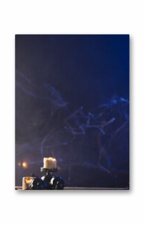 Vertical image of pumpkin, skulls and candles with copy space on dark background
