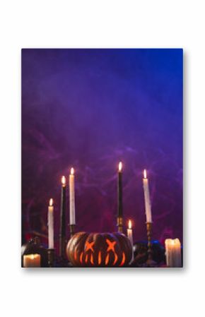 Vertical image of pumpkins and candles with copy space on purple background
