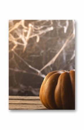 Vertical image of pumpkin and spiderweb decorations with copy space on black background